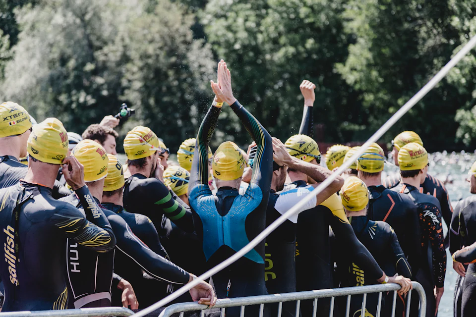 Triatletas con gorro de natación en la salida de una prueba